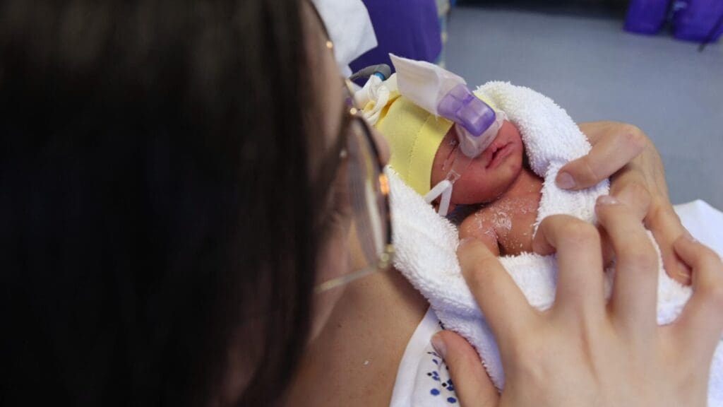 Mujer sosteniendo a un neonato con vástagos nasales