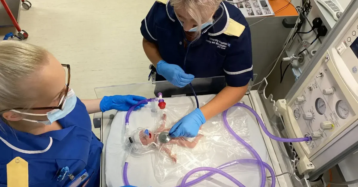 Nurses working on a neonatal patient requiring respiratory care